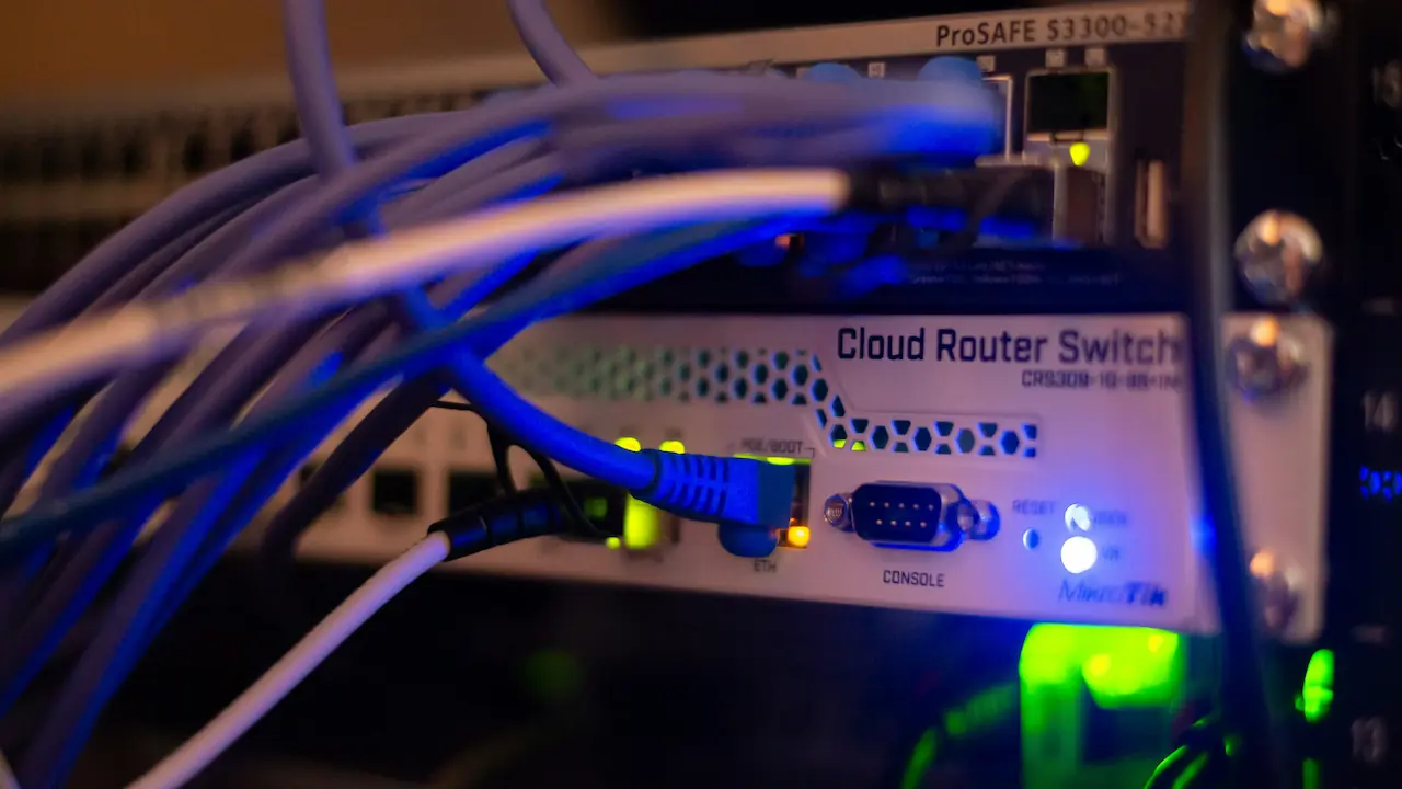 Zbliżenie na urządzenie sieciowe z podłączonymi kablami Ethernet i świecącymi diodami.